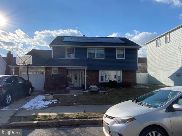 view of front of home with a garage and solar panels