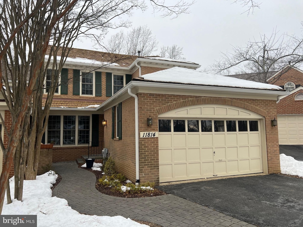 snow covered property featuring a garage