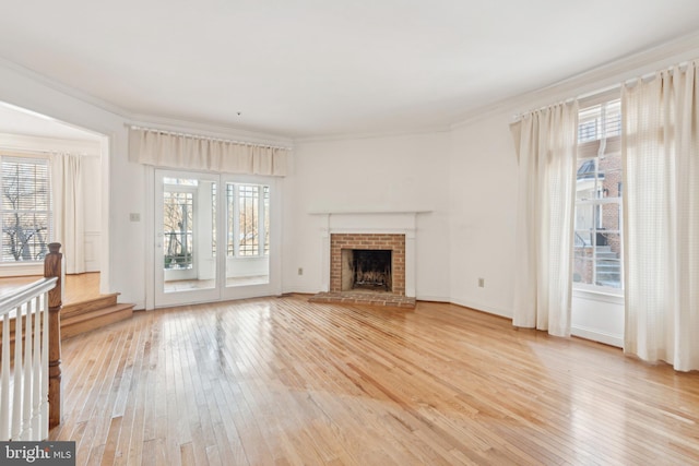 unfurnished living room featuring ornamental molding, light hardwood / wood-style floors, and plenty of natural light