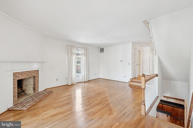 unfurnished living room with a fireplace, light hardwood / wood-style floors, and ornamental molding