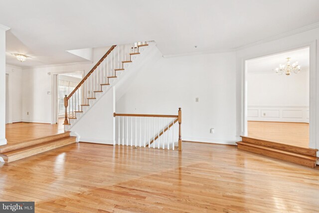 interior space with hardwood / wood-style flooring, a chandelier, and ornamental molding