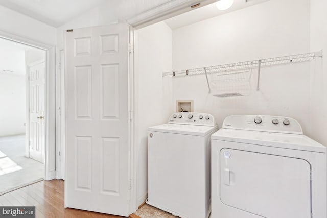 laundry area with washer and clothes dryer and light hardwood / wood-style floors