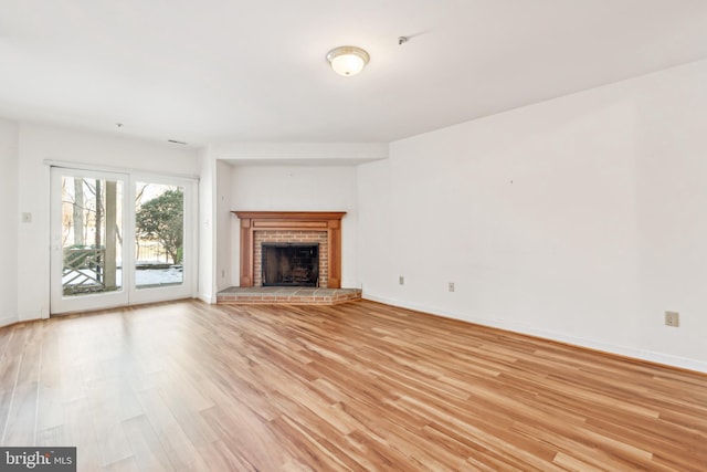 unfurnished living room with a fireplace and light wood-type flooring