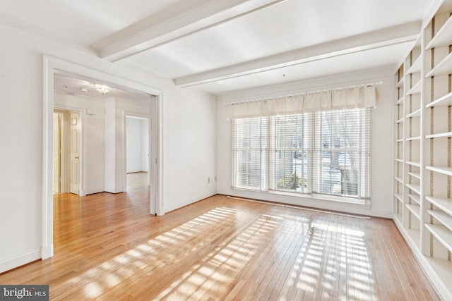 spare room with hardwood / wood-style flooring and beamed ceiling