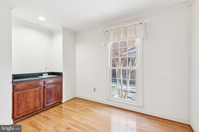 bar featuring sink, crown molding, and plenty of natural light