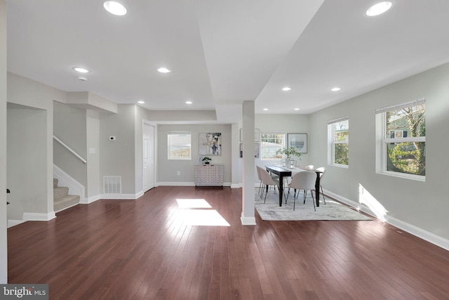 foyer entrance featuring dark wood finished floors, stairs, baseboards, and visible vents