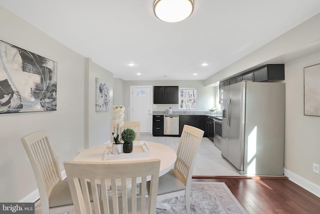 dining room with recessed lighting, baseboards, and light wood-style floors