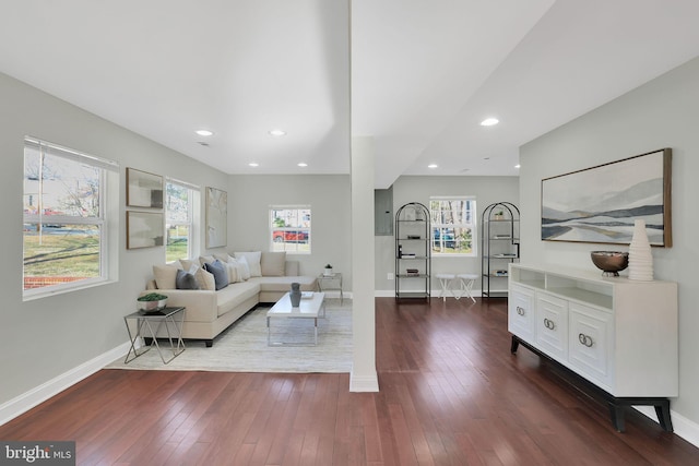 living area with baseboards, plenty of natural light, and dark wood-style floors