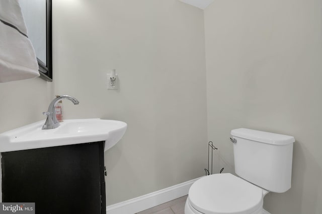 bathroom featuring vanity, toilet, and baseboards