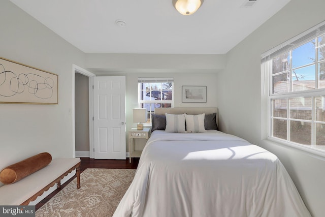 bedroom with visible vents, dark wood-style flooring, and baseboards