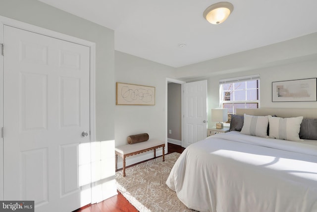 bedroom with baseboards and wood finished floors