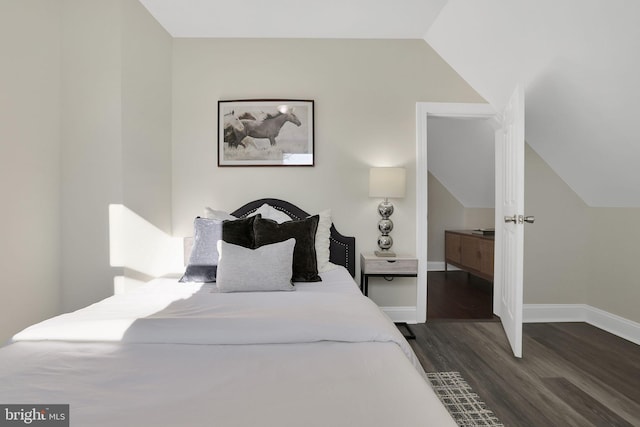 bedroom with baseboards, dark wood-type flooring, and lofted ceiling