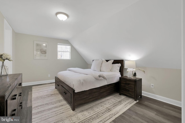 bedroom featuring baseboards, lofted ceiling, and wood finished floors