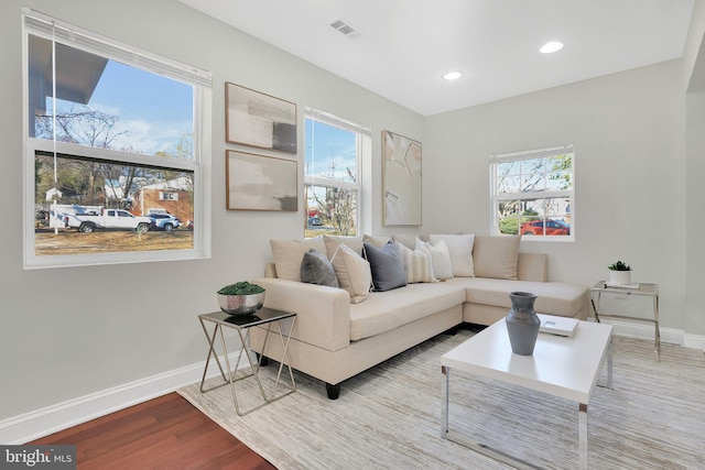 living area featuring recessed lighting, visible vents, baseboards, and wood finished floors