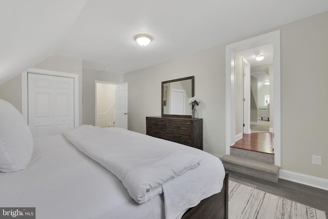 bedroom featuring a closet, baseboards, and dark wood finished floors