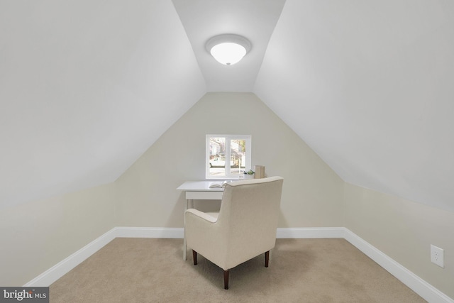 carpeted office space featuring vaulted ceiling and baseboards