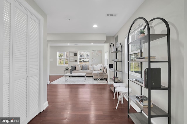 hallway featuring recessed lighting, visible vents, wood-type flooring, and baseboards