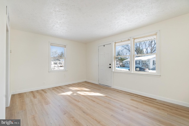 foyer entrance with a healthy amount of sunlight, light hardwood / wood-style flooring, and a textured ceiling