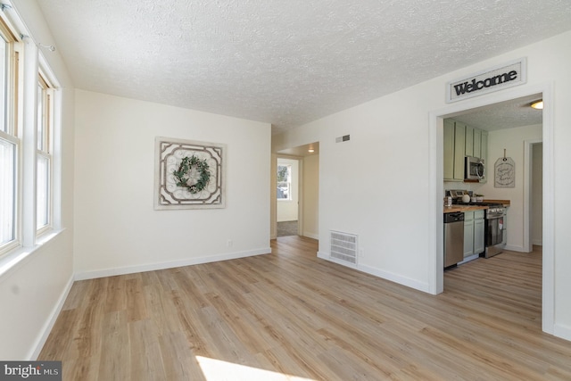 empty room featuring a textured ceiling and light wood-type flooring