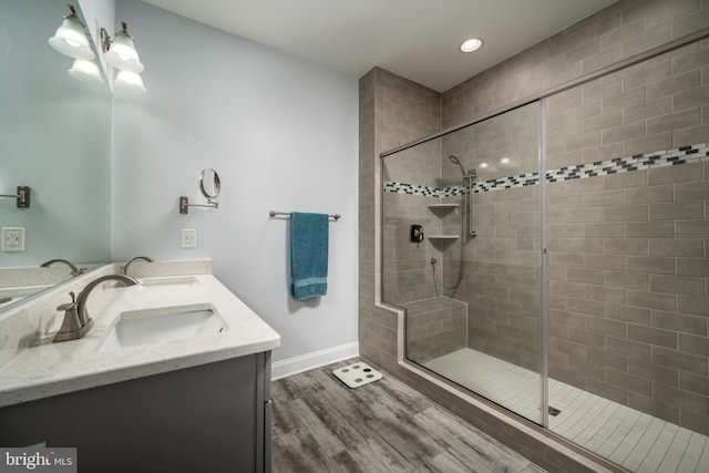 bathroom featuring an enclosed shower, vanity, and hardwood / wood-style floors