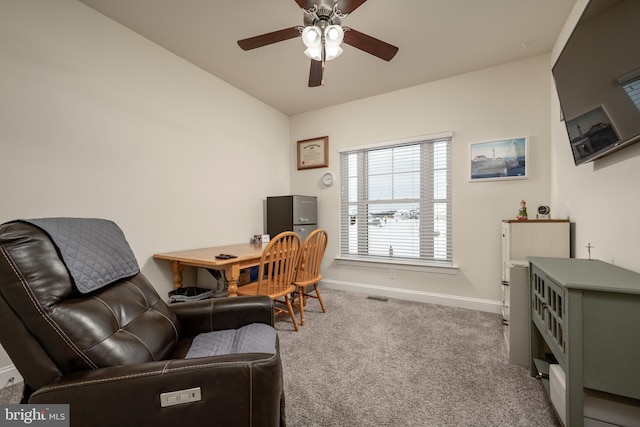 carpeted home office featuring ceiling fan