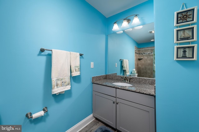 bathroom with vanity and a tile shower