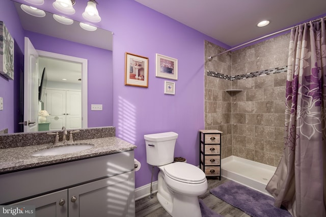 bathroom featuring toilet, a shower with curtain, hardwood / wood-style flooring, and vanity