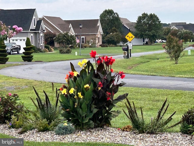 view of community featuring a garage and a yard