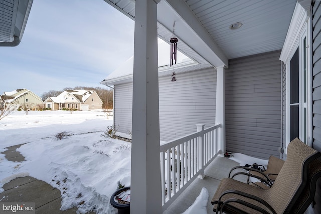 view of snow covered back of property