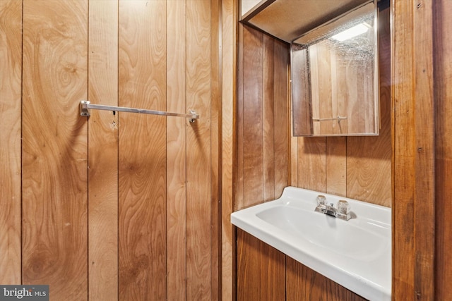 bathroom with sink and wood walls