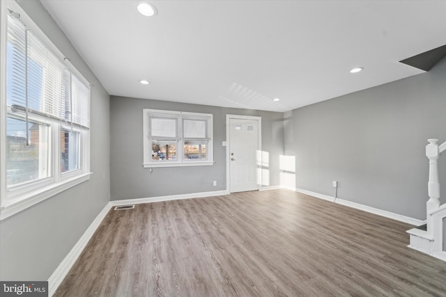 unfurnished living room with a healthy amount of sunlight and hardwood / wood-style flooring