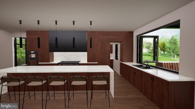 kitchen with sink, wood-type flooring, and hanging light fixtures