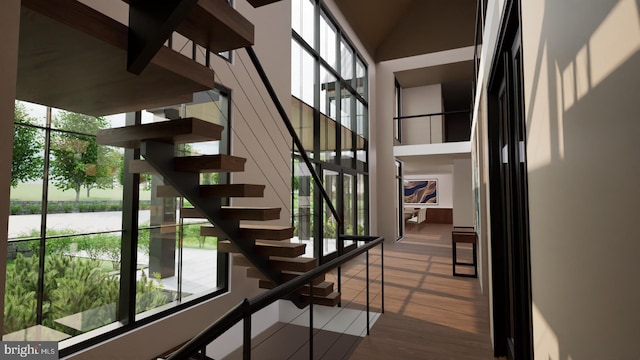 stairway with hardwood / wood-style flooring and a water view