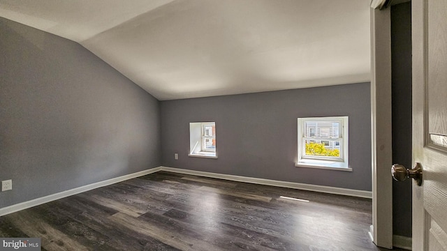 empty room with lofted ceiling and dark hardwood / wood-style flooring