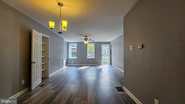 unfurnished living room with ceiling fan with notable chandelier, dark hardwood / wood-style floors, and built in features