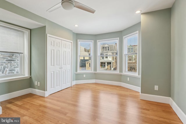 unfurnished bedroom featuring light hardwood / wood-style floors, a closet, and ceiling fan