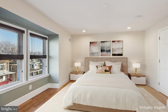 bedroom featuring light hardwood / wood-style flooring and multiple windows