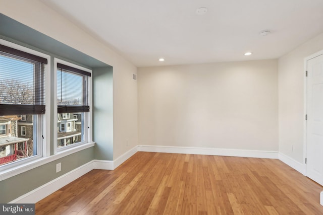 unfurnished room with a wealth of natural light and light hardwood / wood-style flooring