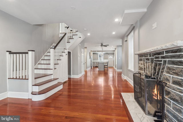 staircase featuring wood-type flooring and ceiling fan