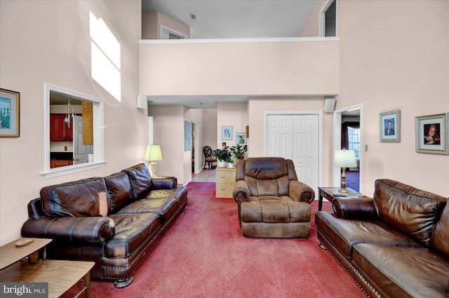 living room featuring a high ceiling and carpet flooring