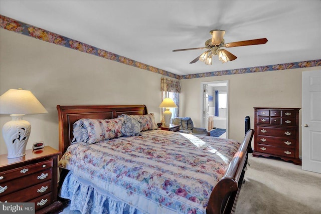 carpeted bedroom featuring ensuite bathroom and ceiling fan