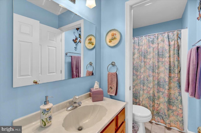 bathroom featuring tile patterned floors, toilet, vanity, and walk in shower