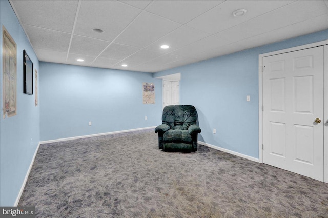 sitting room featuring carpet floors and a drop ceiling