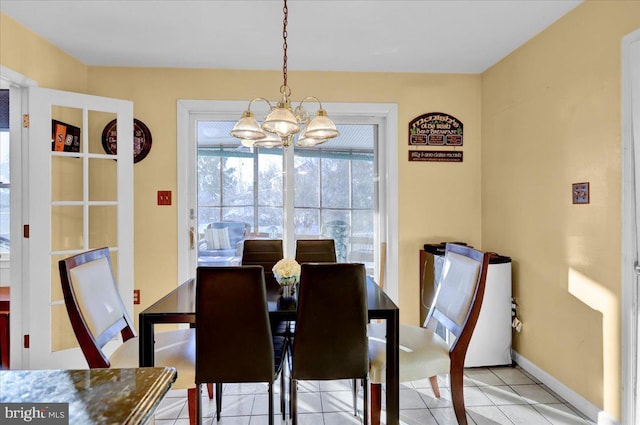 dining space with light tile patterned floors and a chandelier