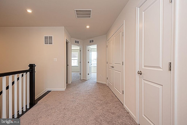 hallway with light colored carpet