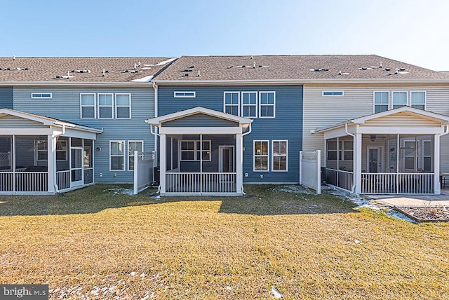 back of property featuring a sunroom and a lawn