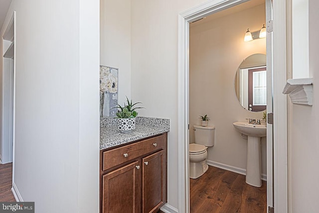 bathroom with hardwood / wood-style floors, sink, and toilet