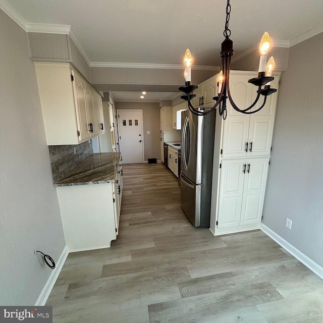 kitchen featuring white cabinets, ornamental molding, stainless steel fridge, and light hardwood / wood-style flooring