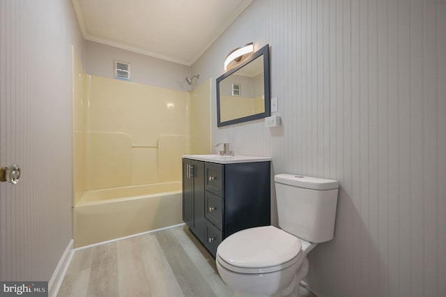 full bathroom with washtub / shower combination, toilet, crown molding, wood-type flooring, and vanity