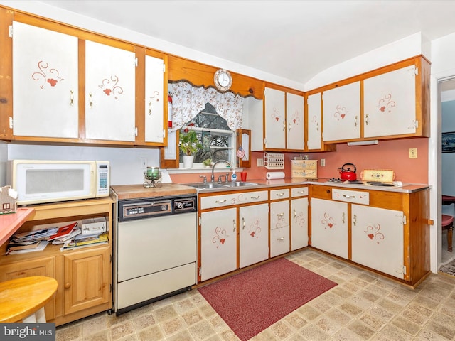 kitchen featuring white cabinetry, sink, white appliances, and lofted ceiling